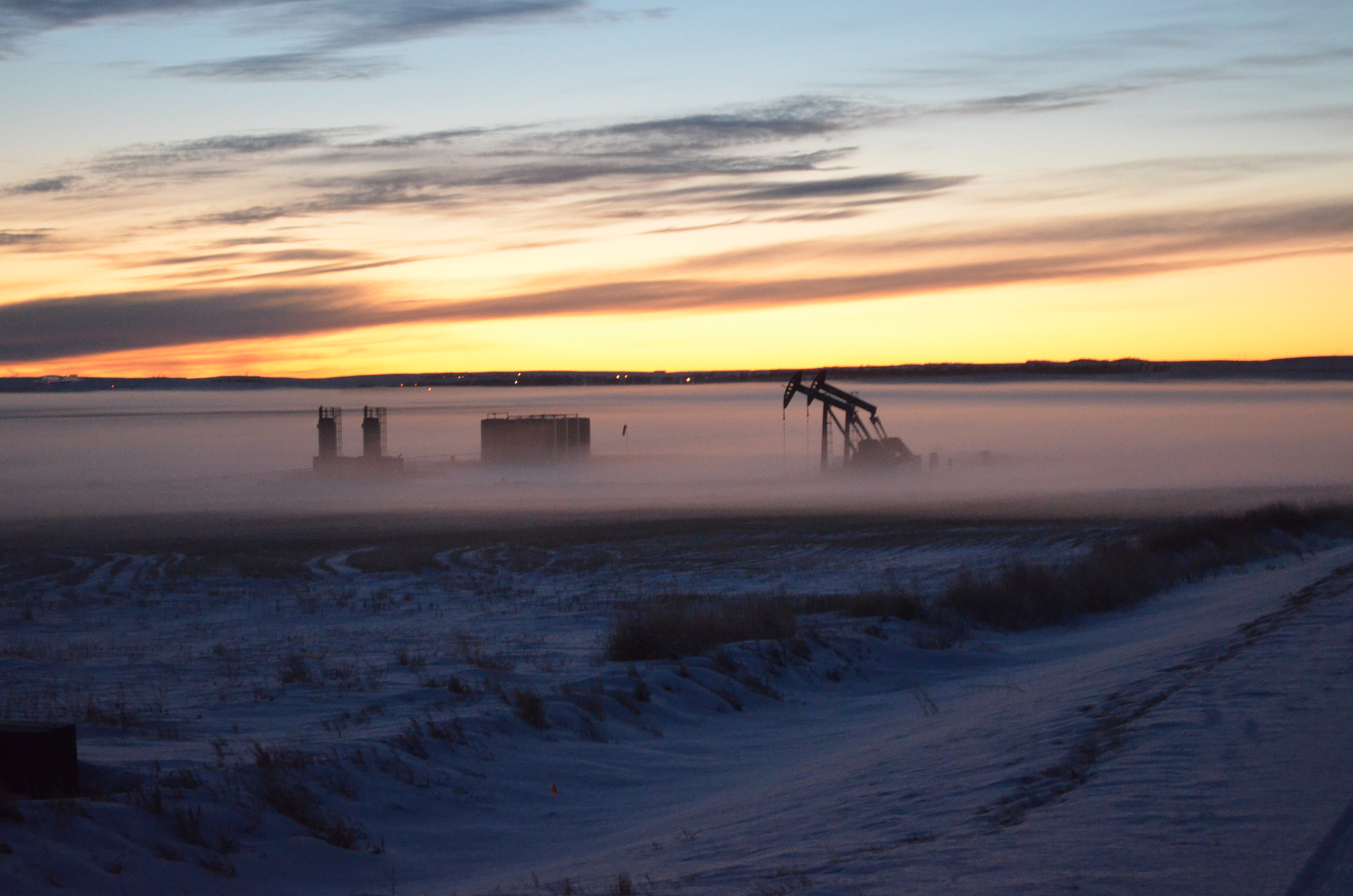 A well pad surrounded by morning fog.